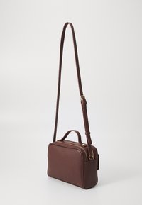 Braune Lederhandtasche mit verstellbarem Trageriemen, rechteckiger Form und doppeltem Reißverschluss. Verfügt über einen oberen Griff und eine dezente, strukturierte Oberfläche.