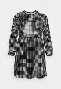 Czarna i biała sukienka w wzór houndstooth z długimi rękawami, okrągłym dekoltem i elastyczną talią. Miękka tkanina o lekko teksturowanym wykończeniu.
