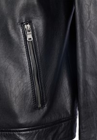 Zwarte leren jas met een ritsvak, een gladde textuur en een subtiele glans. De rits is zilverkleurig met een rechthoekige trekker.