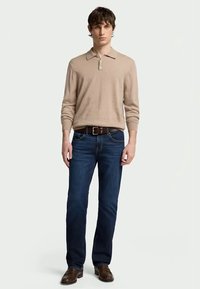 Beige long-sleeve polo shirt, blue denim jeans, brown leather belt, brown shoes. Simple design, medium fit, standard collar, and smooth texture.
