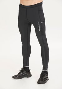 Svarta träningsbyxor i stretchigt material, med en sidficka och ordet "ENDURANCE" tryckt i vitt. Slät textur med åtsittande design.