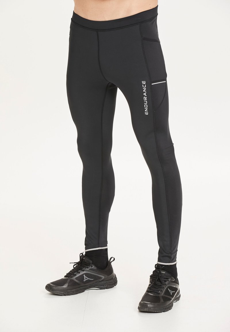 Svarta träningsbyxor i stretchigt material, med en sidficka och ordet "ENDURANCE" tryckt i vitt. Slät textur med åtsittande design.