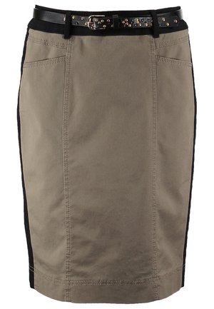 Kobieta ubrana w czarną koszulę zapinaną na guziki, khaki spódnicę do kolan z czarnym paskiem, czarne rajstopy, czarne botki oraz trzymająca czarną kopertówkę.