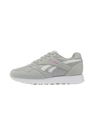 Zapatilla Reebok gris claro con detalles en blanco, cordones y logo en el lateral, mostrada de perfil sobre un fondo blanco.