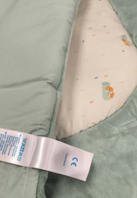 Soft, mint green blanket with plush texture, featuring a patterned inner fabric in pale pink with colorful confetti and a fox design.
