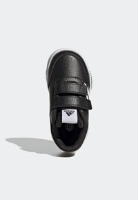Černé tenisky s texturovaným syntetickým svrškem, dvěma suchými zipy, bílou podešví a černým interiérem. Na jazyku a boku se nachází logo Adidas.