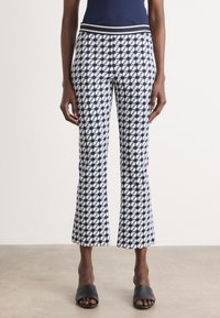 Marineblauwe en witte gebloemde cropped broek met een aansluitende tailleband en een uitlopende zoom, gemaakt van lichtgewicht stof. Draag het met zwarte instappers.