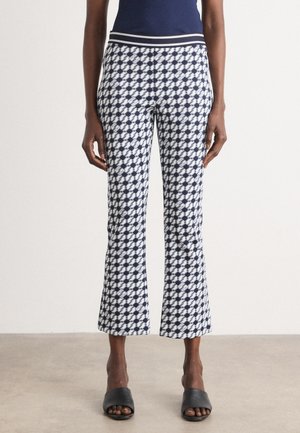 Marineblauwe en witte gebloemde cropped broek met een aansluitende tailleband en een uitlopende zoom, gemaakt van lichtgewicht stof. Draag het met zwarte instappers.