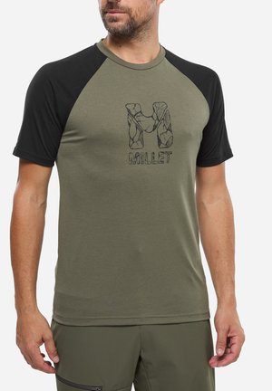 Homme portant un t-shirt à manches raglan olive et noir avec un "M" texturé et le logo "MILLET" centré sur la poitrine.