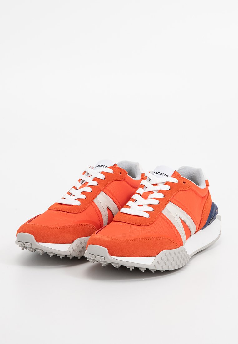 Oranje sportieve schoenen met witte veters, grijze accenten en een gestructureerde zool. Kenmerken zijn een bovenkant van suede en textiel met contrasterende strepen.