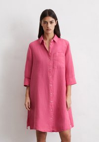 Rozā linu krekliņa kleita ar pogām priekšā, apkakli, trīs ceturtdaļu piedurknēm un krūšu kabatu. Maiga tekstūra, brīvs piegriezums.