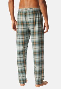 Geruite pyjamabroek in groen, wit en oranje tinten, met een relaxed fit, elastische tailleband en een lichte, gestructureerde stof.