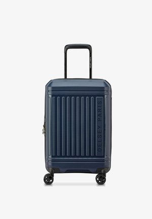 Valigia rigida blu navy con righe verticali, manico telescopico e quattro ruote nere. Presenta un logo del brand sul lato.