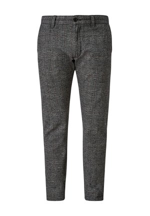 Gros plan sur une personne portant un pantalon à carreaux gris avec une main dans la poche latérale, associé à un haut blanc à manches longues.