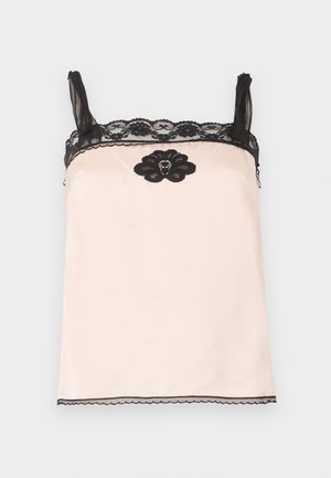 Camisole en satin rose pâle avec bordure en dentelle noire sur les bretelles et le haut, ornée d'une fleur en dentelle noire avec de petites perles centrée sous l'encolure.