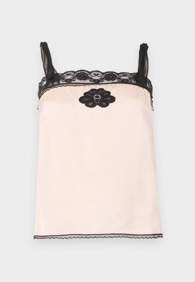 Camisole en satin rose pâle avec bordure en dentelle noire sur les bretelles et le haut, ornée d'une fleur en dentelle noire avec de petites perles centrée sous l'encolure.
