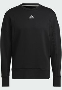 Felpa nera realizzata in un morbido tessuto testurizzato. Presenta un collo rotondo, maniche lunghe e un piccolo logo bianco adidas sul petto.