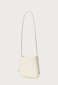 Krém színű bőr keresztpántos táska ezüst lánc vállpánttal, lágy vonalakkal és minimalista dizájnnal. A táska elején diszkrét márkajelzés található.