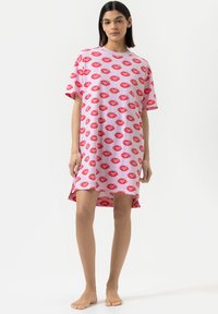 Abito t-shirt rosa con una stampa di labbra rosse su tutta la superficie. Maniche corte e dettaglio dell'orlo asimmetrico, tessuto morbido.