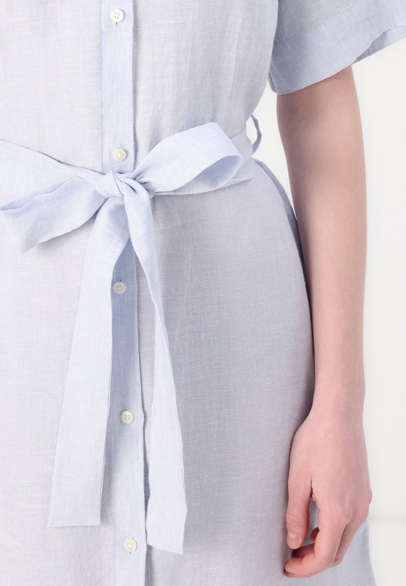 Helles blaues Leinenkleid mit kurzen Ärmeln, Knopfverschluss und einem gebundenen Gürtel in der Taille, aus strukturiertem Stoff mit weichem Finish.