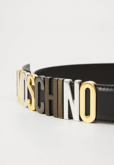 Fekete bőrvászon öv fém betűkkel, amelyek "MOSCHINO" feliratot alkotnak arany, ezüst, szürke és fekete színekben. Simított felület és merész dizájn jellemzi.