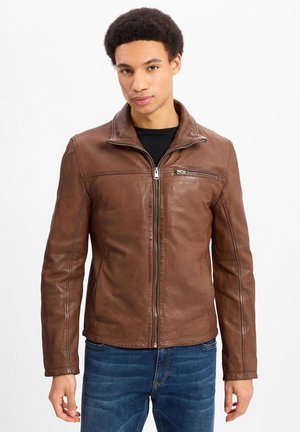 Braune Lederjacke mit einem Reißverschluss vorne, Stehkragen und zwei Vordertaschen. Weiche Textur mit Nahtdetails.