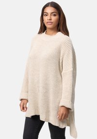 Hellbeige gestrickter Pullover mit lockerer Passform, rundem Ausschnitt, weiten Ärmeln und gerippten Bündchen. Strukturierten Stoff und seitliche Schlitze am Saum.