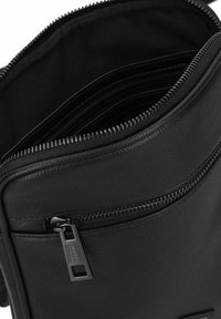 Borsa nera in ecopelle con molteplici scomparti interni, chiusure zip e una superficie testurizzata, che mette in evidenza linee morbide e un design elegante.