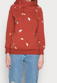 Rustfarvet sweatshirt med hætte, dekoreret med metalliske bladmønstre i guld og hvid. Blødt stof med ribkant ved ærmegab og kant.