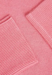 Tessuto lavorato a maglia rosa con diverse trame a coste, caratterizzato da sezioni lisce e motivi a contrasto, che mostrano un aspetto morbido e elastico.