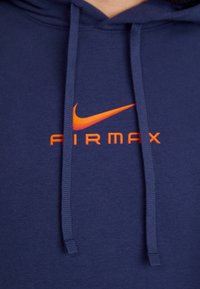 Mörkblå hoodie med en stor orange Nike swoosh-logga och texten "AIRMAX". Tillverkad av mjukt material med dragsnören.