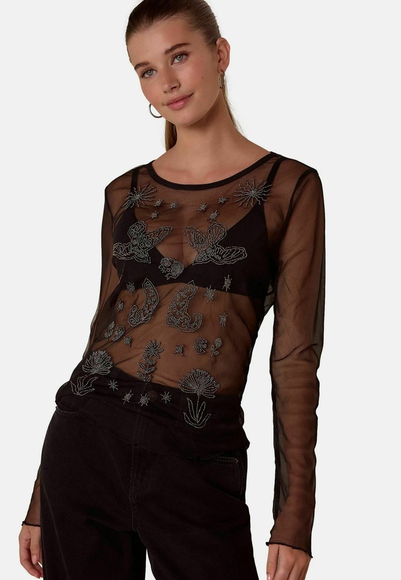 Black sheer long-sleeve top featuring intricate silver embroidery of butterflies, flowers, and celestial motifs on the front.
