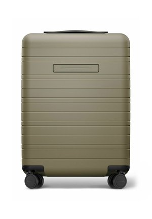 Valise rigide compacte vert olive avec des rainures horizontales et quatre roues multidirectionnelles noires, vue de face sur fond blanc.