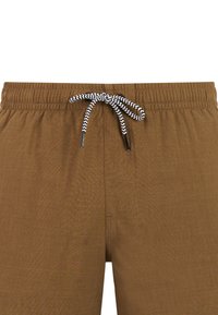 Shorts à taille élastique marron avec un cordon de serrage noir et blanc en zigzag noué en nœud papillon au centre devant.