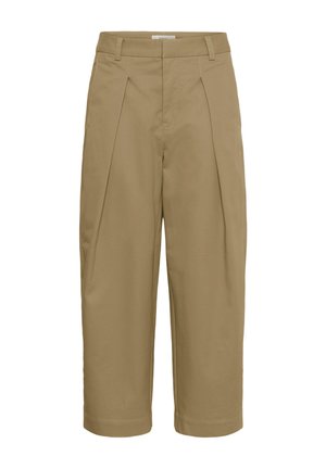 Pantalon beige court avec des plis, des passants pour ceinture, et une coupe droite.