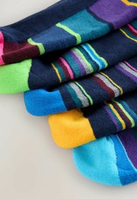 Calcetines de algodón coloridos con diseños a rayas y lisos, con acentos en azul marino, verde, rosa, azul, púrpura y amarillo. Textura suave.