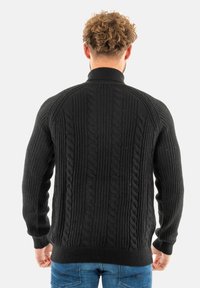 Maglione nero a maglia con motivi a trecce, colletto alto, polsini e orlo a costine. Design testurizzato sulla schiena, maniche lunghe, vestibilità casual.