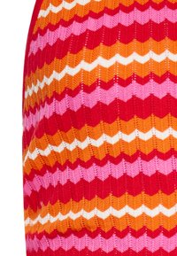 Tessuto a maglia con un motivo a zigzag nei colori rosso, rosa, arancione e bianco. La texture è a coste, con colori variegati che creano un design vivace.