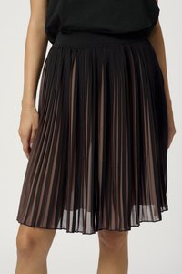 Jupe plissée noire avec un voile transparent, présentant des plis verticaux et une taille élastique, longueur genoux avec une texture lisse.