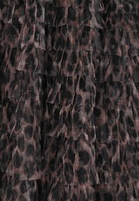 Leopard-tryk med flæser i nuancer af sort og brun. Gennemsigtige, teksturerede lag med et blødt, flydende udseende.