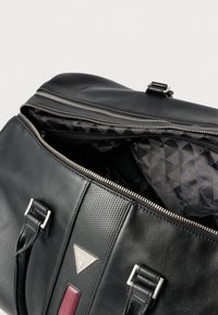 Fekete bőrtáska cipzáras záródással, texturált díszítésekkel, ezüstszínű fém kiegészítőkkel és geometriai mintájú, mintás belsővel.