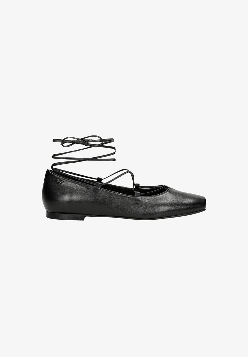 Ballerines en cuir noir avec un bout pointu, dotées de brides croisées à la cheville et d'une texture lisse. Design minimaliste avec un profil bas.