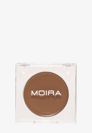 Crème de maquillage compacte ronde marron dans un boîtier plastique carré transparent avec le nom de la marque MOIRA sur la surface.