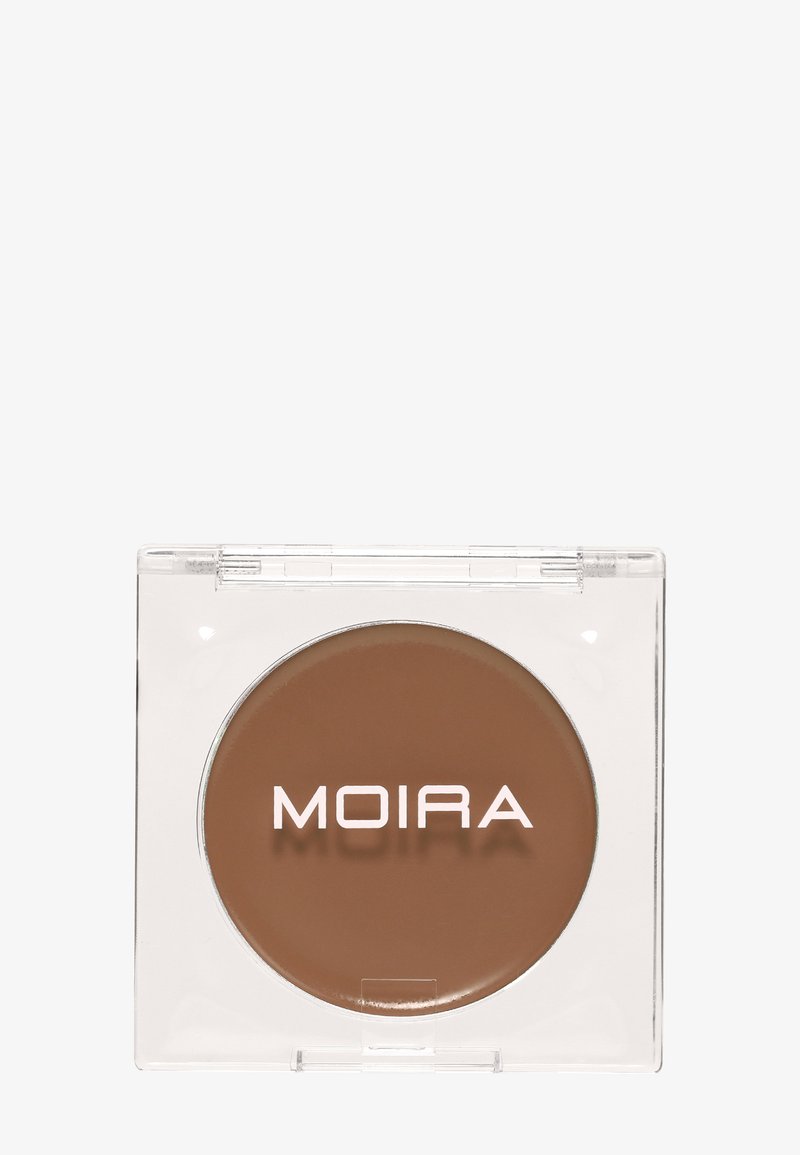 Crème de maquillage compacte ronde marron dans un boîtier plastique carré transparent avec le nom de la marque MOIRA sur la surface.