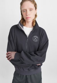 Houtscharcoal zip-up sweatshirt met een hoge kraag, ribbelmanschetten en tailleband. Beschikt over een cirkelvormig logo met 'PARIS' prominent gedrukt.