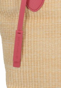 Bolso de mano de paja trenzada en color natural. Cuenta con una correa de faux cuero texturizado en color rosa y una etiqueta con el logo "Tom Tailor" grabado.