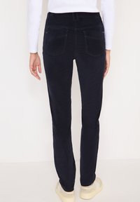 Mörkblå manchesterbyxor med slim fit, fem fickor och en lätt texturerad yta. Har sömdetaljer och ett midjeband.