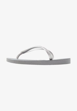 Sive flip-flop iz gumija, s teksturirano podplatno in tankimi, prozornimi trakovi. Oblikovanje je preprosto in minimalisticno.