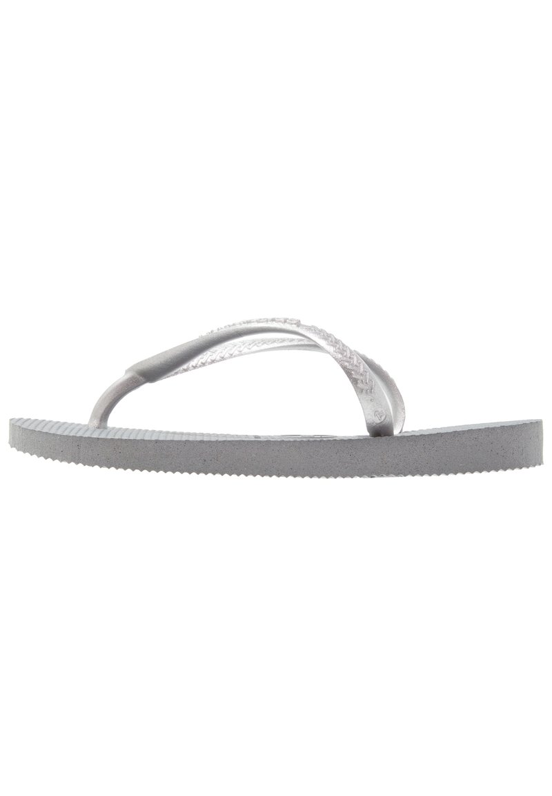 Harmaa flip-flop, joka on valmistettu kumista, ja jossa on teksturoitu pohja sekä ohuet, läpinäkyvät hihnat. Suunnittelu on yksinkertainen ja minimalistinen.