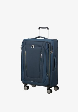 Valigia soft-shell blu navy con quattro ruote girevoli, manico telescopico, tasca frontale con zip e maniglia laterale.